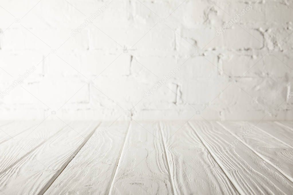 white wooden tabletop and white wall with bricks