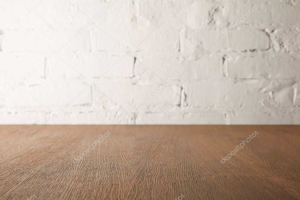 brown wooden tabletop and white wall with bricks
