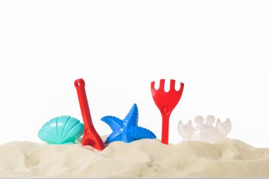 Plastik plaj oyuncakları kum üzerinde beyaz izole