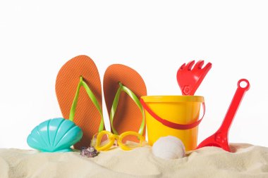 Pair of flip flops in sand isolated on white clipart