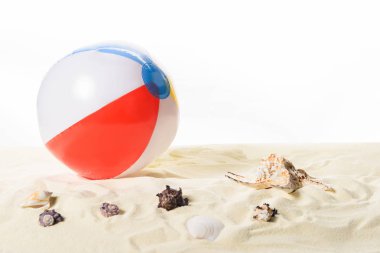 Beach ball with seashells in sand isolated on white clipart