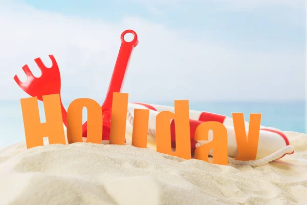 Beach Toys Holiday Inscription Sand Blue Sky Background — Free Stock Photo