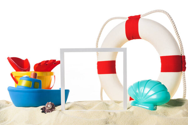 Beach toys with life ring and frame in sand isolated on white