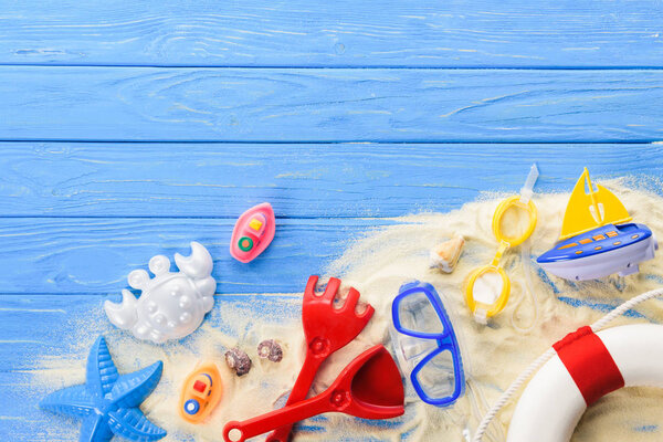 Diving mask and beach toys on blue wooden background