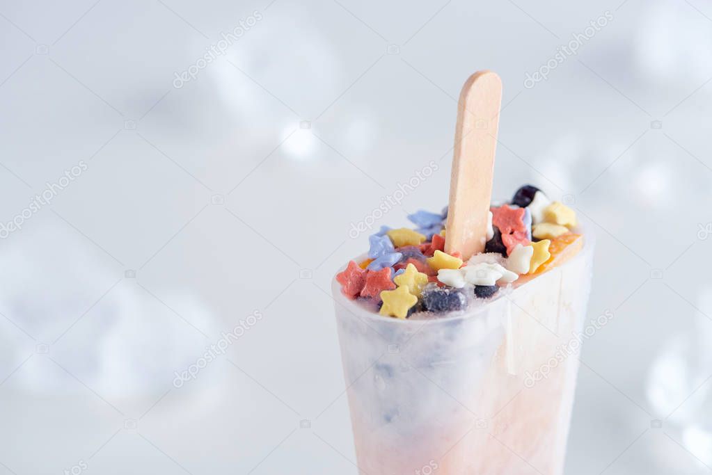 close-up view of delicious fruity homemade ice cream and ice cubes on grey background