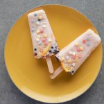 Top view of delicious fruity ice cream on yellow plate on grey