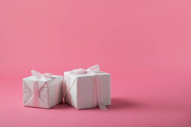 İki kutu pembe bir arka plan üzerinde yay ile hediye