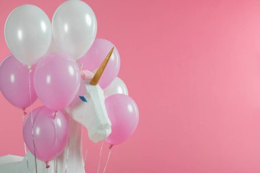 Oyuncak tek boynuzlu at pink izole pembe ve beyaz balonlar arasında