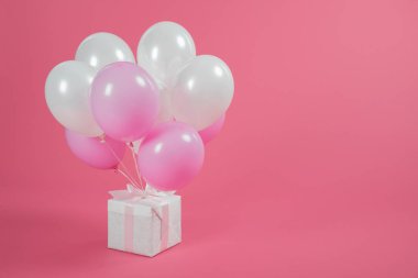 Hediye kutusu ve pembe bir arka plan üzerinde balon