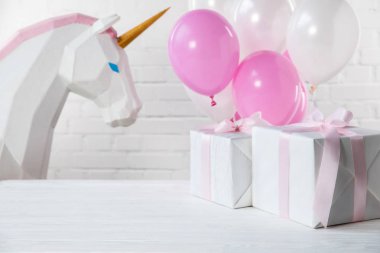Arka plan dekoratif tek boynuzlu at ve hediyeler ile balon üzerinde beyaz tuğla duvar