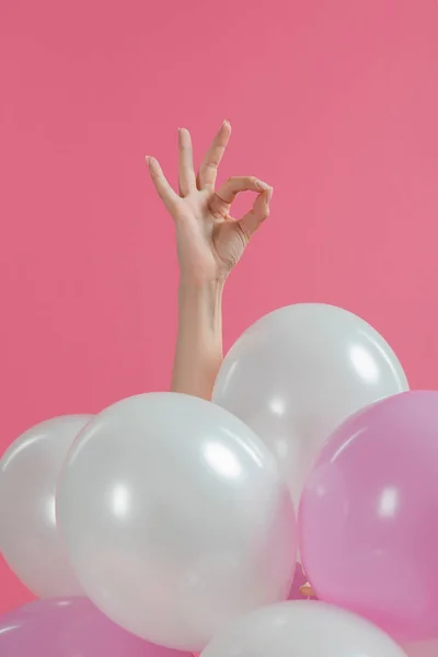 ピンクと白の風船がピンクに分離された上 の標識を示す女性の手 — ストック写真