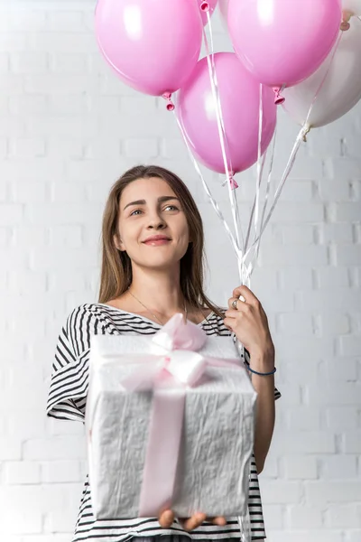 Smiling Woman Holding Gift Box Balloons White Brick Wall Background — Stock Photo, Image