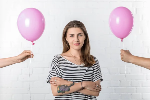 Leende Flicka Stående Mellan Händer Som Håller Rosa Ballonger Vitt — Stockfoto