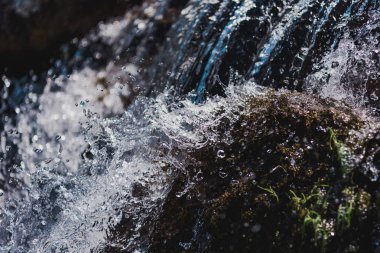 selective focus of water flowing with splashes outdoors clipart
