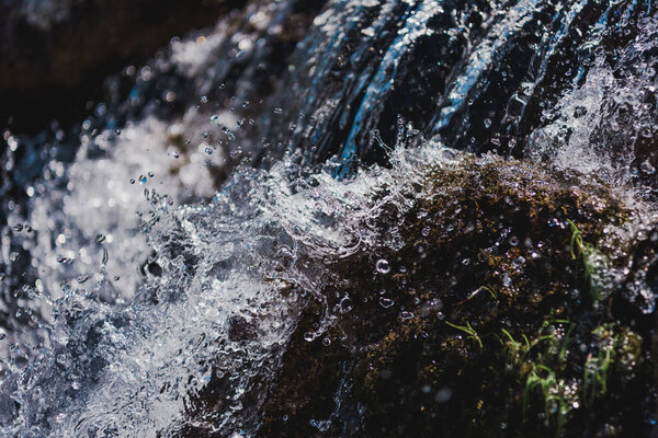 selective focus of water flowing with splashes outdoors