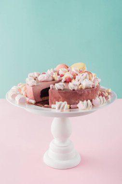 sweet cake with marshmallows and macarons on cake stand clipart