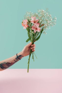 buket pembe lily çiçekler ile tutan dövmeli kadın görünümünü kırpılmış