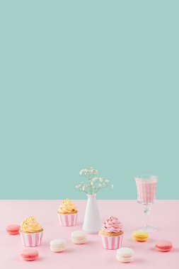 cupcakes, macarons, milkshake ve kopya alanı pastel zemin üzerine Vazoda Çiçekler