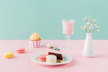 macarons, kek, pasta ve milkshake pastel arka plan üzerinde