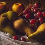 Primo piano di uva fresca con pere e mele sulla garza