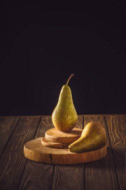 close-up shot of ripe pears on stacked boards and on rustic wooden table on black clipart
