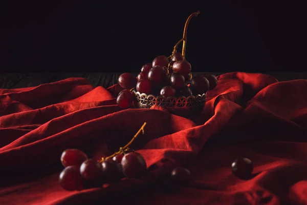 黑色红色窗帘上老式金属碗中的葡萄特写镜头 — 图库照片