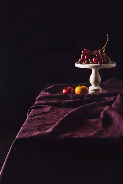 Σταθείτε Σταφύλια Και Μήλα Στο Τραπέζι Πτυχώσεις Στο Μαύρο — Φωτογραφία Αρχείου