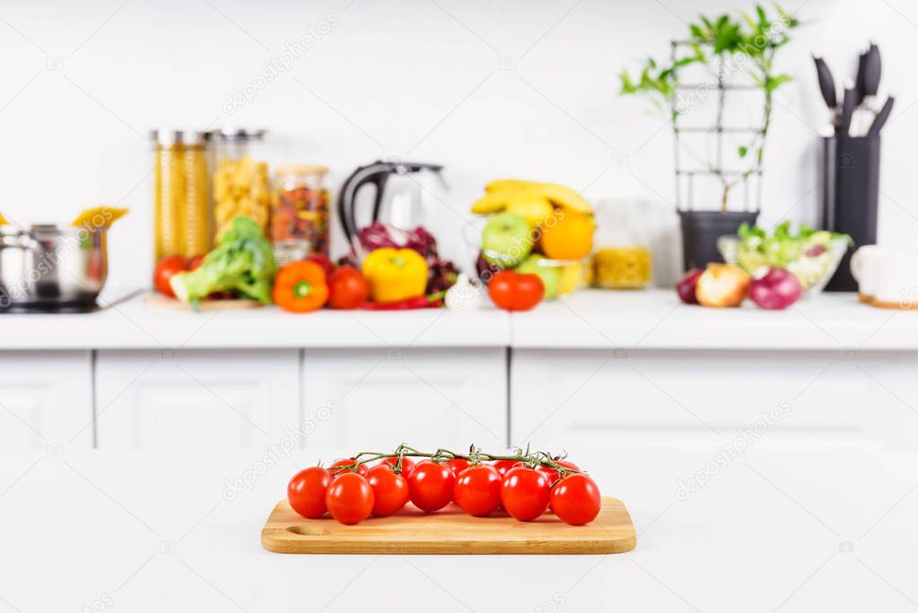 ripe cherry tomatoes on cutting board in light kitchen