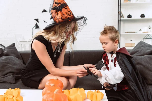 Mãe Filho Pequeno Trajes Halloween Com Morcegos Papel Preto Sofá — Fotos gratuitas