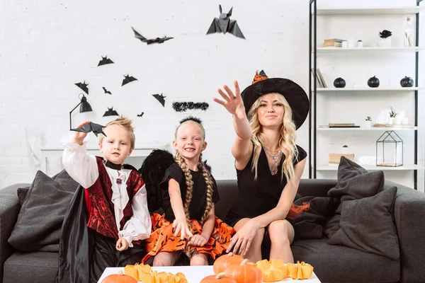 Portrait Mother Kids Halloween Costumes Throwing Black Paper Bats Home — Stock Photo, Image