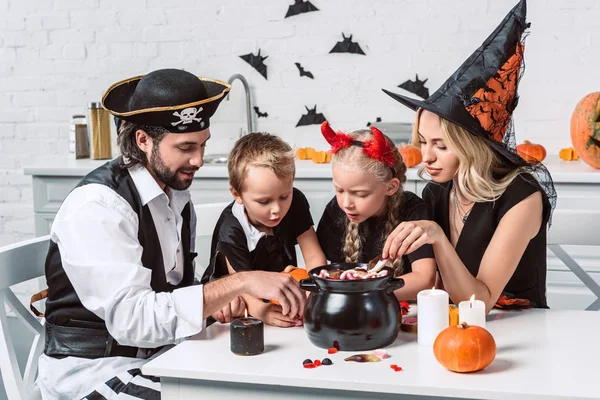 Família Vários Trajes Halloween Mesa Com Panela Preta Com Guloseimas — Fotografia de Stock