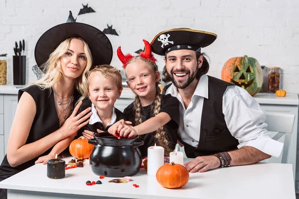 Familia Varios Disfraces Halloween Mesa Con Olla Negra Con Golosinas —  Fotos de Stock