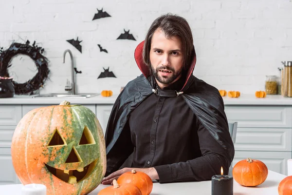 Portrét Člověka Upíra Halloween Kostým Sedí Stolu Dýně Kuchyni Doma — Stock fotografie