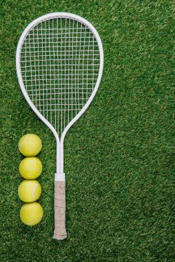 Tenis raket ve topları yeşil çim üstten görünüm