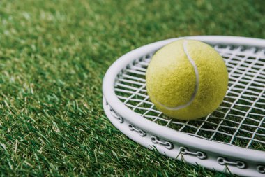 Tenis topu bakış yeşil çim üzerinde yalan raket üzerinde kapatın