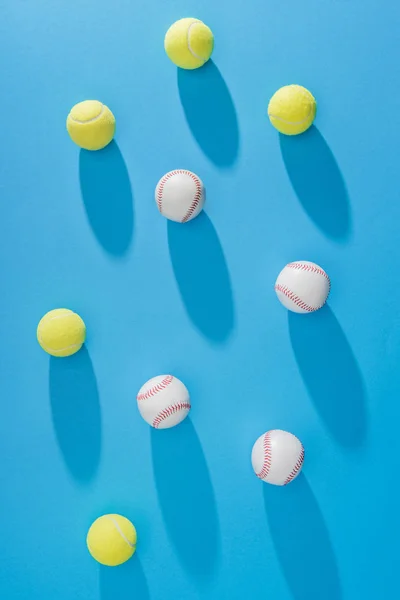 Draufsicht Auf Arrangierte Tennis Und Baseballbälle Vor Blauem Hintergrund — kostenloses Stockfoto