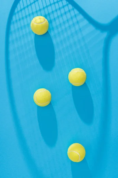 Top View Arranged Tennis Balls Racket Shadow Blue Backdrop — Free Stock Photo