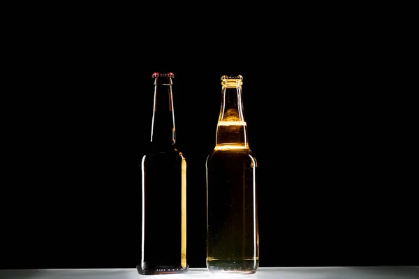Licht Donker Bierflessen Aan Tafel Zwarte Achtergrond Minimalistische Concept — Stockfoto
