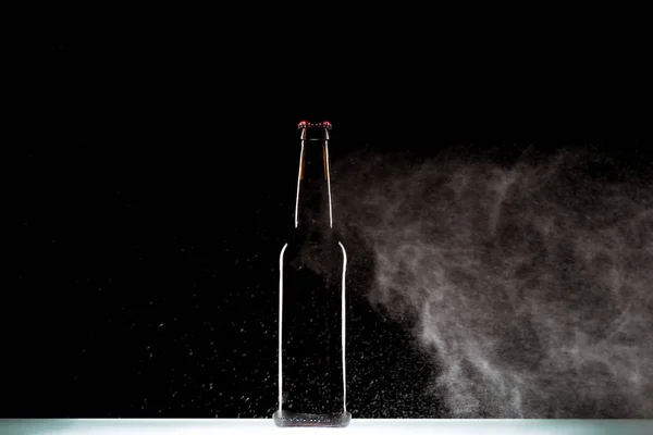 Botella Cerveza Oscura Con Agua Pulverización Superficie Sobre Fondo Negro — Foto de stock gratis