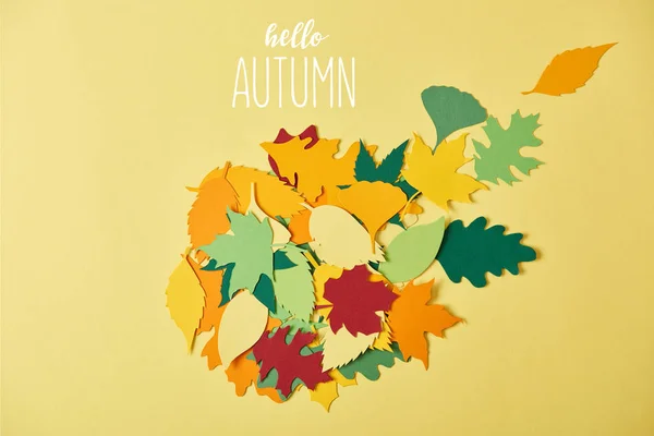 黄色の背景に こんにちは秋 レタリングとカラフルな Papercrafted の葉を持つフラット レイアウト  — 無料ストックフォト
