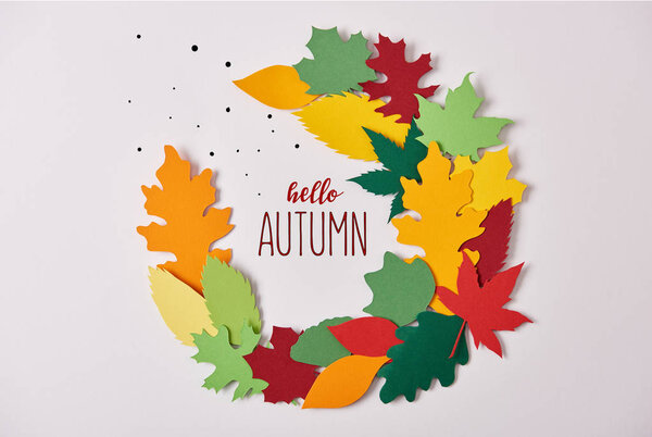 flat lay with colorful papercrafted foliage with "hello autumn" lettering on white background