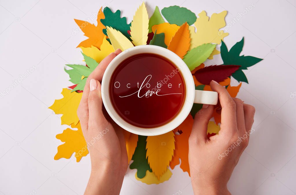 partial view of woman holding cup of hot tea with 