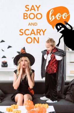 little boy in vampire costume screaming at mother in witch halloween costume at home with 