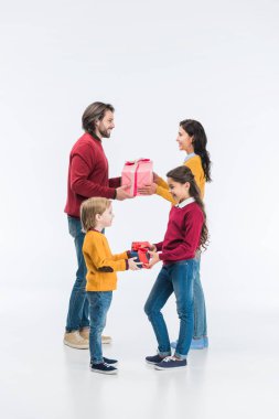 Ebeveynler ve çocuklar sunan gülümseyen hediyeler beyaz izole birbirlerine sarılmış 