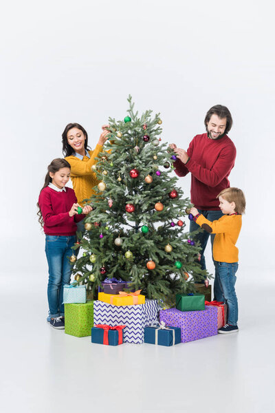 Happy family decorating christmas tree with presents isolated on white