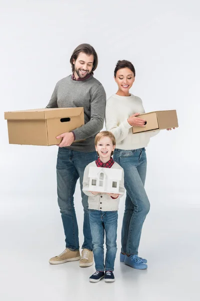 Little smiling boy holding carton house ready to move with his family into new house isolated on white