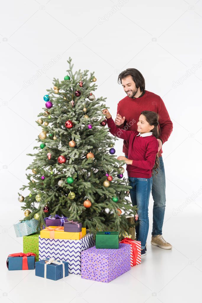smiling father with daughter decorating christmas tree with presents isolated on white