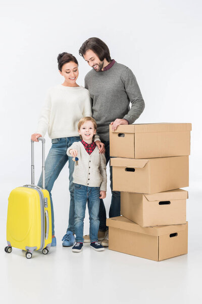 улыбчивый мальчик, держащий ключ от нового дома, готов переехать с семьей в новый дом, изолированный на белом
 