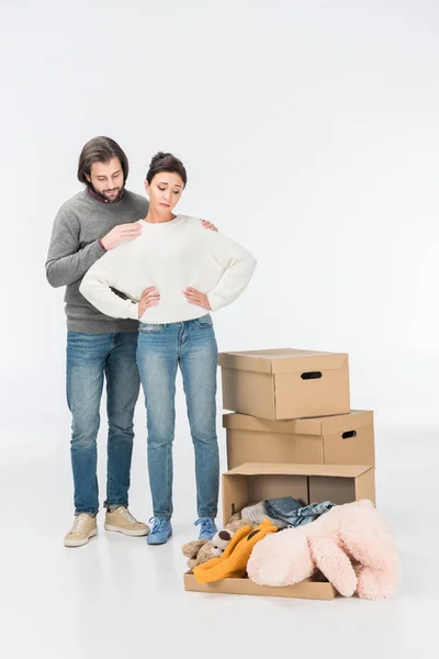 Husband Hugging Thoughtful Wife Looking Carton Box Toys Isolated White — Free Stock Photo