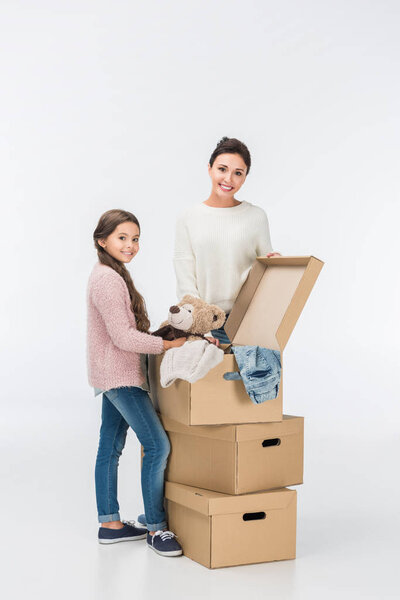 мать и дочь с коробками переезда в новый дом изолированы на белом
 